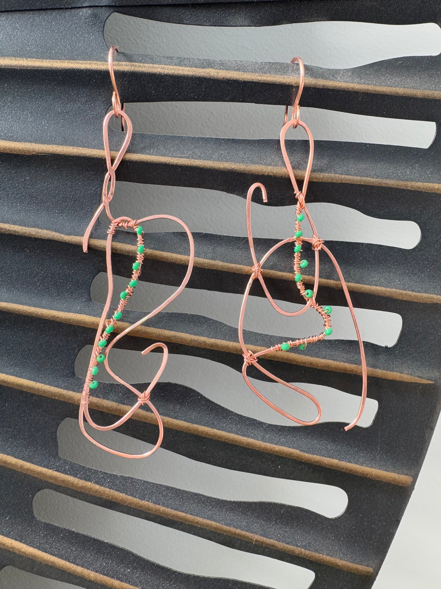 Abstract copper earrings with green beads