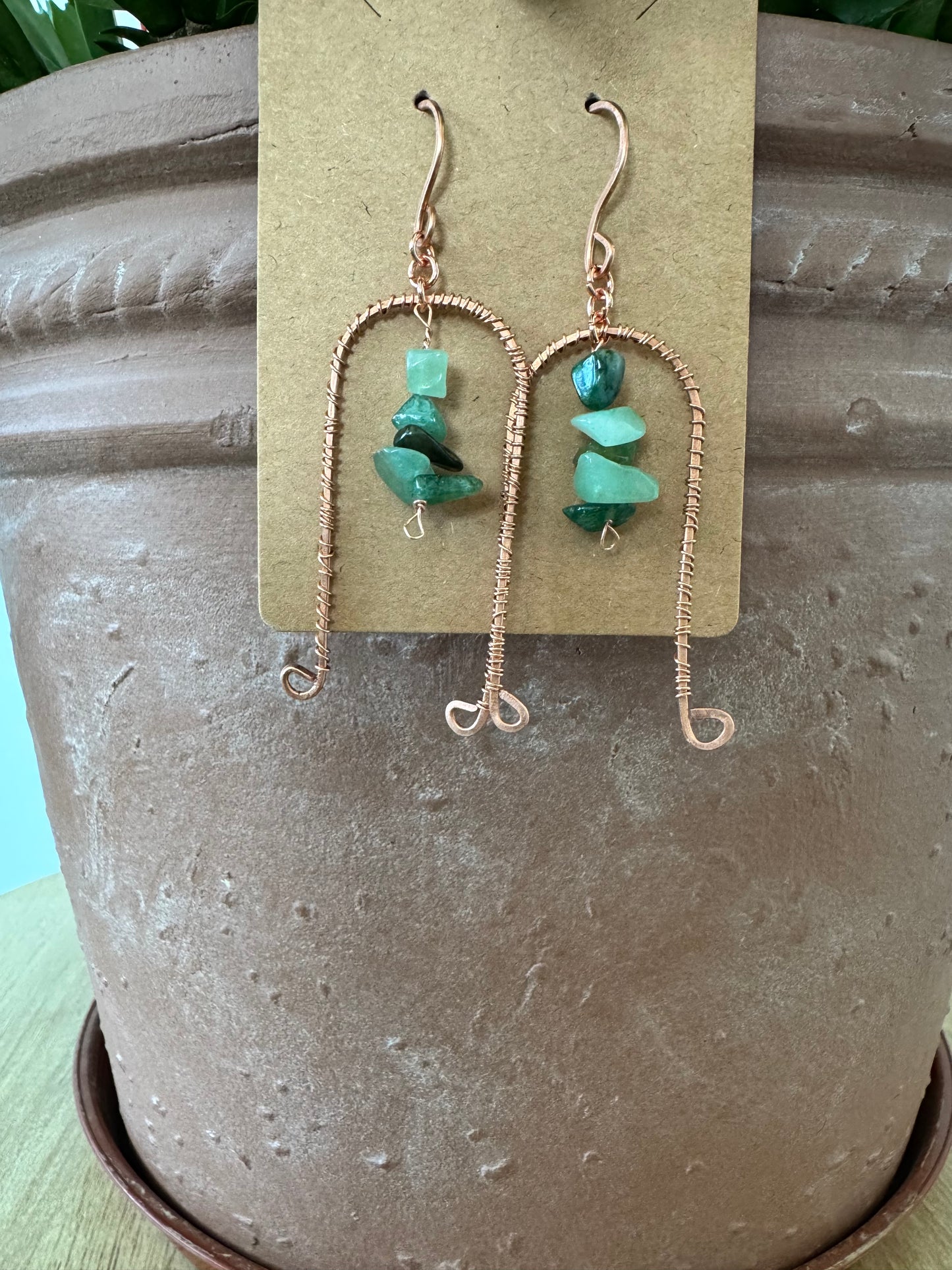 Arched copper earrings with green stones